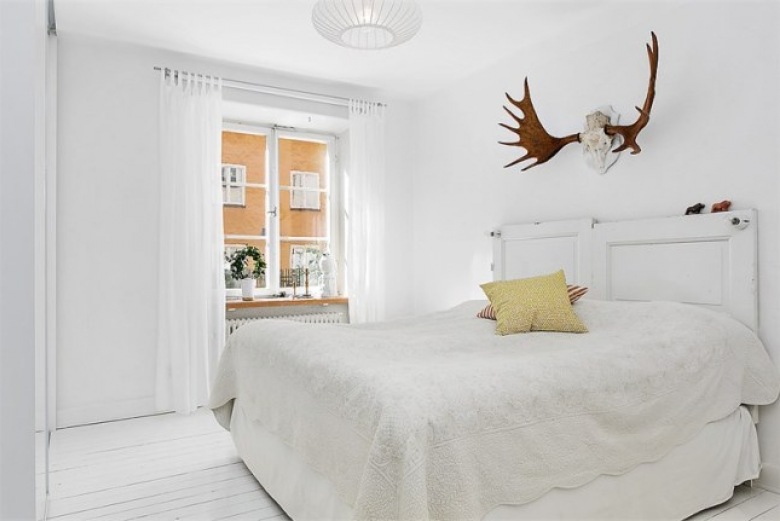 Białe łóżko vintage , poroże jelenia w aranżacji białej sypialni (24870)