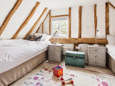 Pokój dla dzieci na wiejskim poddaszu z drewnianymi belkami,szarymi szafkami i turkusową skrzynią vintage (24935)