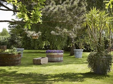 Pomysł na ogród z kompozycją dużych donic kamiennych i drewnianych z roślinnymi kompozycjami (25041)