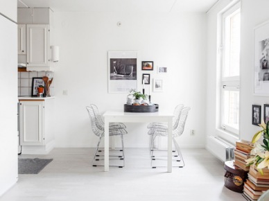 Biała jadalnia przy kuchni w białej aranzacji wnętrza z czarno-białymi fotografiami na ścianach (24706)
