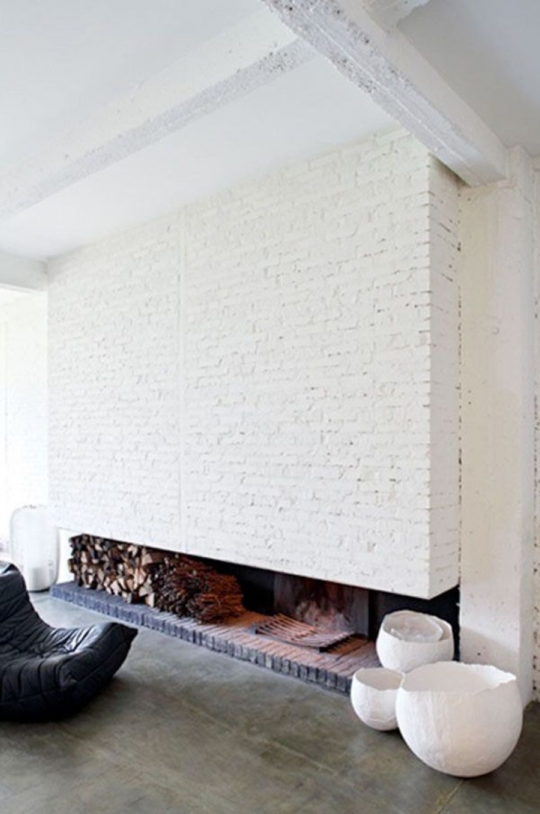 widowiskowa ściana z białej cegły, która zrazem jest częścią kominka w prostej, nowoczesnej...