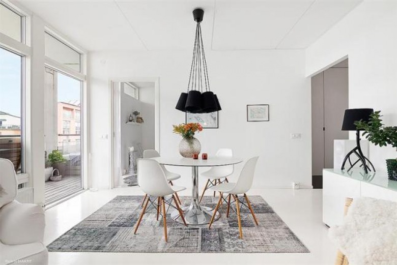 Szaro-biały dywan vintage,okrągły biały stół,krzesła vitra i czarne nowoczesne lampy (24779)