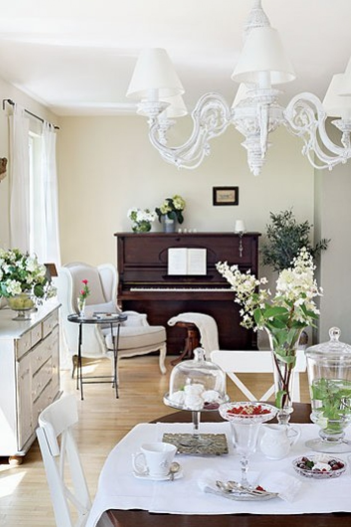 Francuskie białe meble  i żyrandol i brązowe drewniane pianino w salonie (21275)