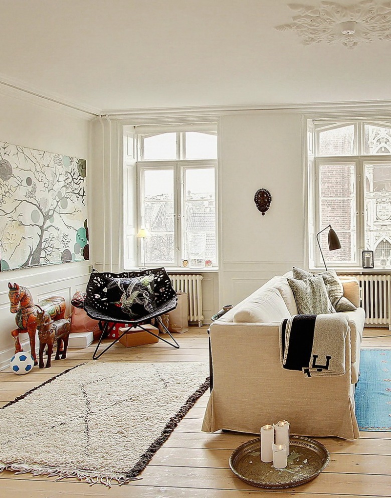 Nowoczesne obrazy,naturalne drewno,tkane dywany i proste witryny w skandynawskim salonie (25400)