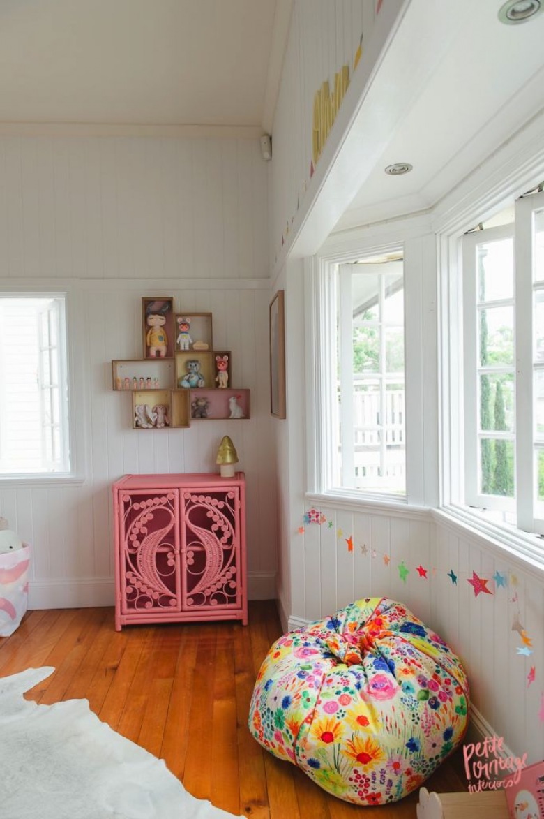 Drewniana podłoga w pokoiku dziecięcym pięknie wybija się na tle białej i szarej ściany. Różowa komoda w zestawieniu z...
