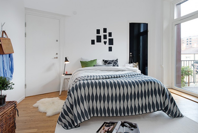 Aranżacja skandynawskiej sypialni z szaro-białą narzutą na łóżku (21916)