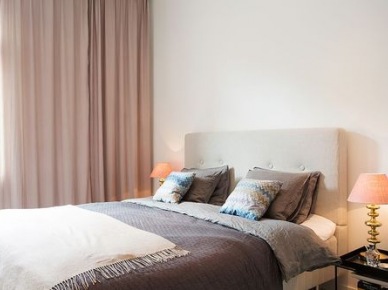 Biało-beżowa sypialnia skandynawska z poduszkami na łóżku z wzorem kolorowego szewronu (25424)