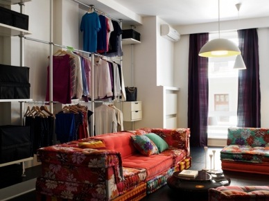 Otwarta garderoba na ścianie w salonie z kolorowymi sofami w stylu bohemy (23679)