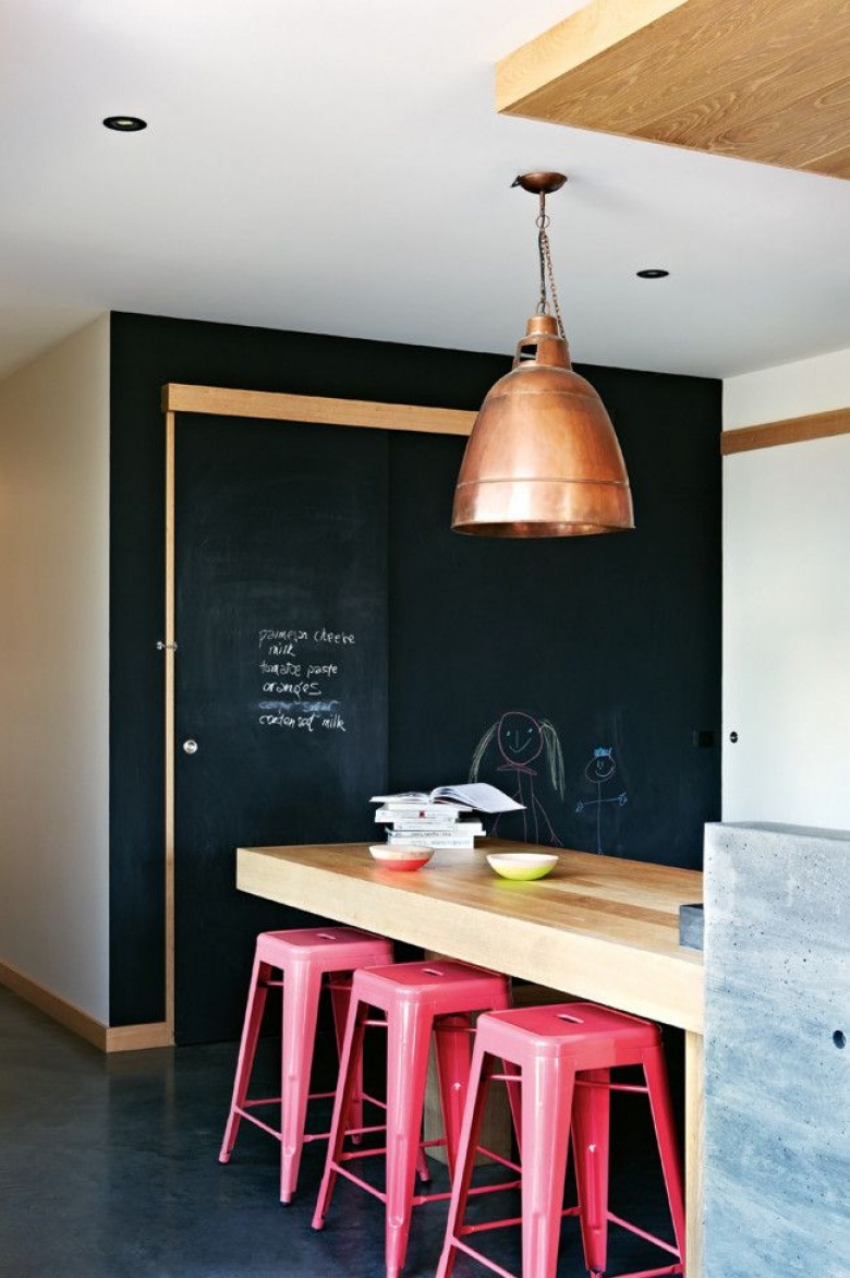 Różowe wysokie stołki przy drewnianej ladzie w kuchni z czarną ścianą z farby tablicowej (25296)