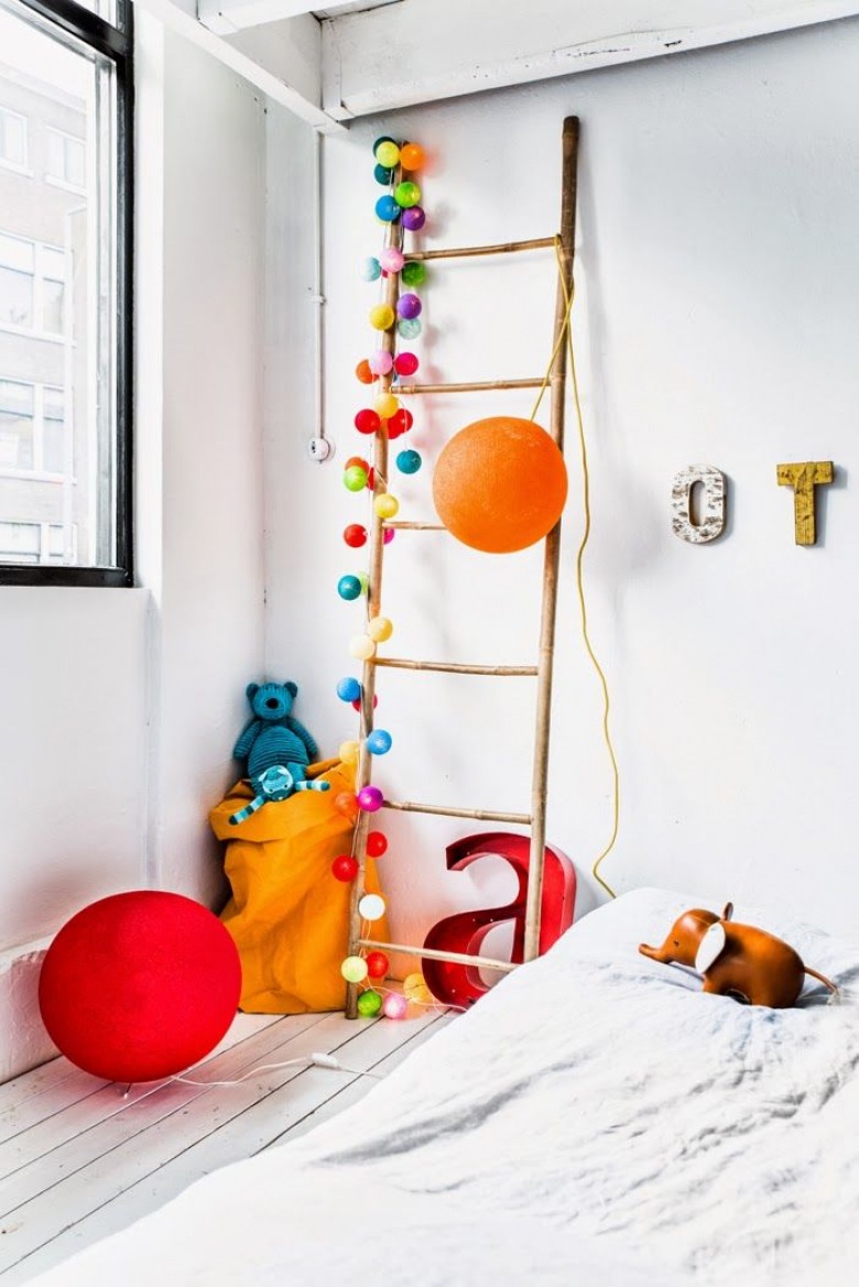 Kolorowe pomponiki i kule na drewnianej drabinie dekoracyjnej w pokoju dziecięcym (26919)