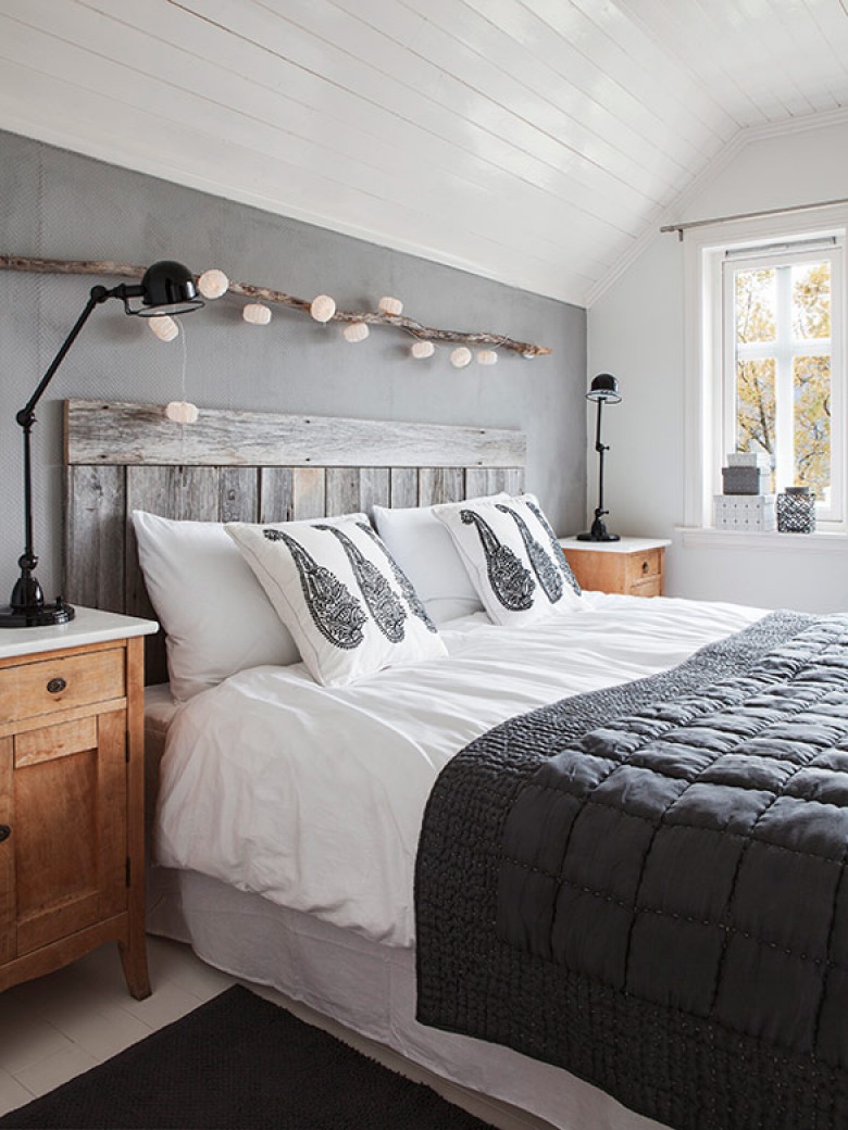 Światełka zawieszone tuż nad drewnianą ramą łóżka są idealną dekoracją i dodają całej sypialni smaku.