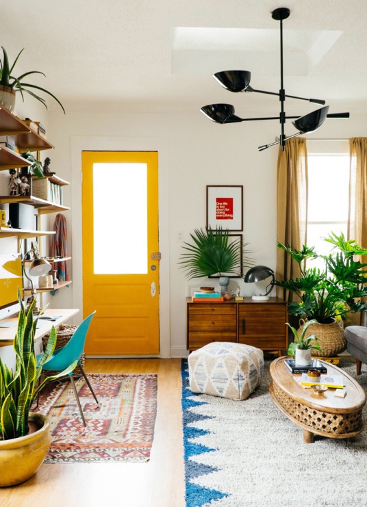Kolorowe drzwi w mocno nasyconym żółtym kolorze przyciągają do siebie całą uwagę w eklektycznym salonie. Obok innych...