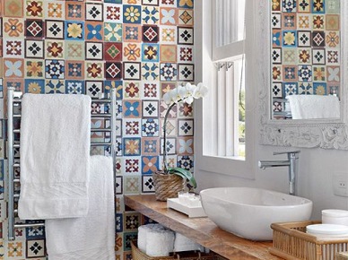 Absolutnie oryginalna aranżacja łazienki dzięki zaskakującej ścianie wyłożonej wielobarwnymi płytkami. Rozmaite wzory tworzące pewnego rodzaju mozaikę przywodzą na myśl marokańskie skojarzenia. Drewniane elementy oraz świeża biel równoważą dynamiczną część...
