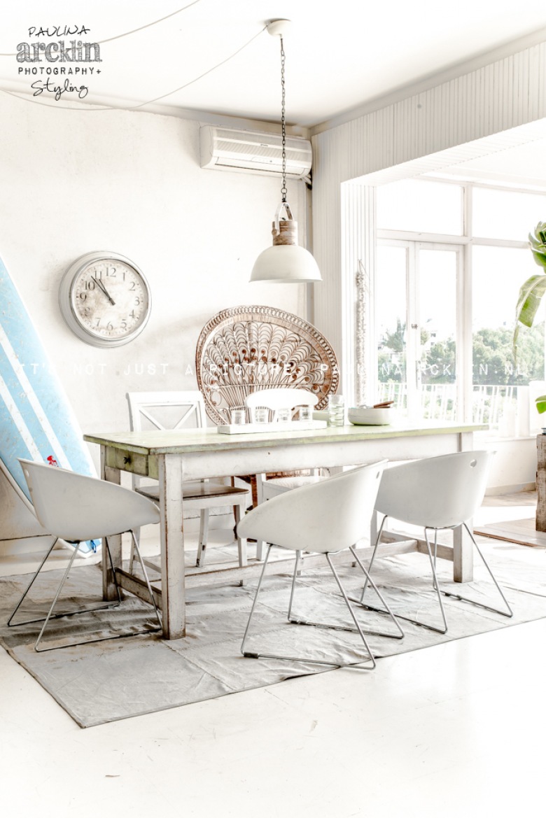 Biała aranżacja jadalni z bielonym stołem w stylu vintage i nowoczesnymi krzesłami na metalowych płozach (22485)