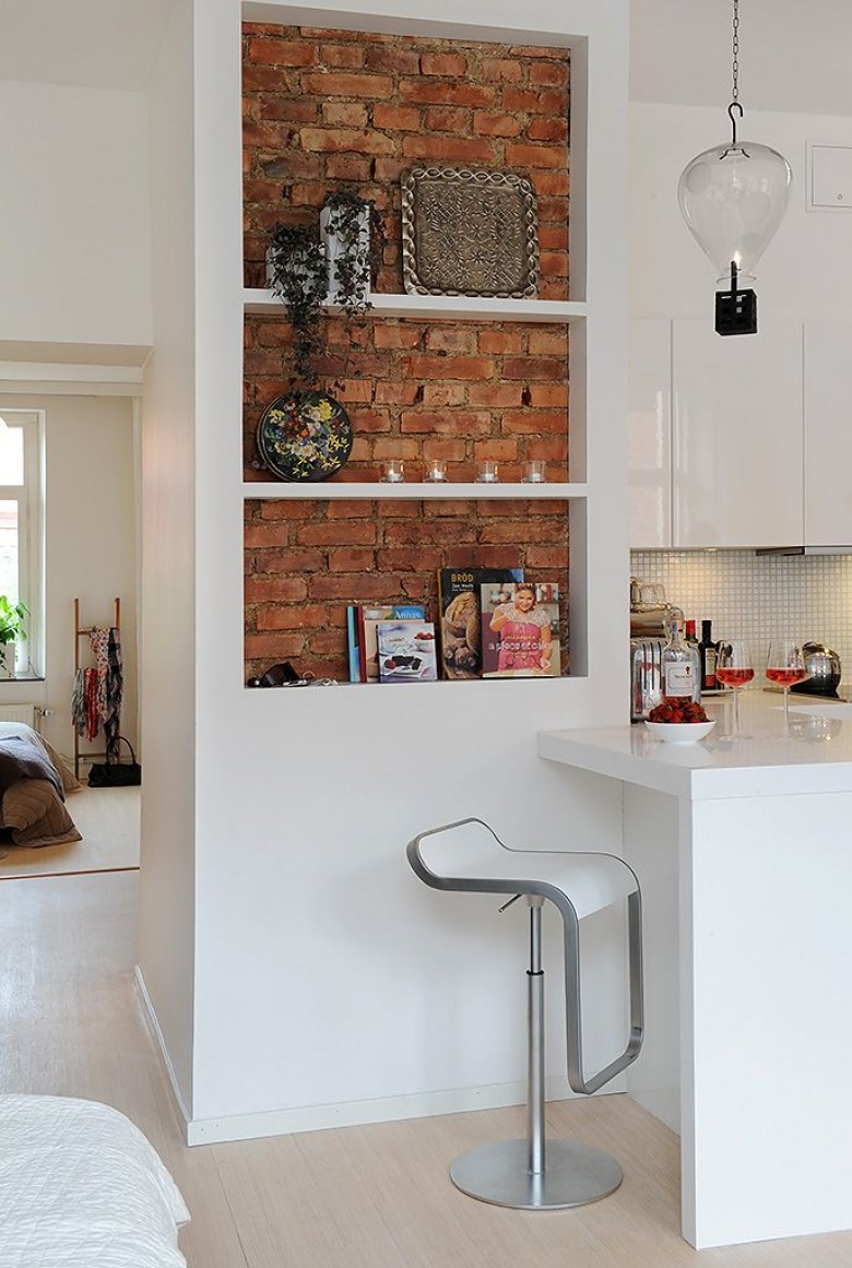 Biała zabudowa z pólkami w kuchni ze ścianą z cegły (21428)