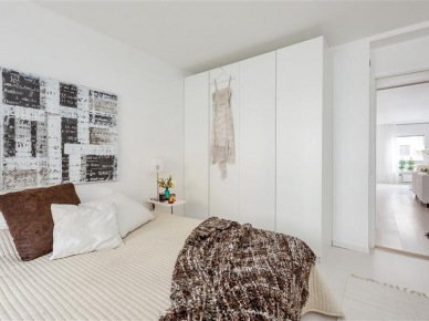 Biała szafa,nowoczesny obraza,brązowa poduszka i beżowa narzuta na łóżko (22442)