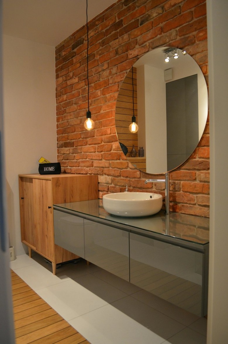 Aranżacja oryginalnej łazienki w eklektycznym stylu. Różnego rodzaju meble i dodatki, jak okrągłe lustro czy...