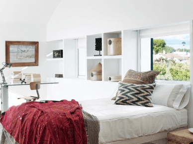 Murowane wapienne półki,drewniane lustro i łóżko,drewniana skrzynia i dywan ze skóry bydlęcej w aranżacji sypialni (25607)