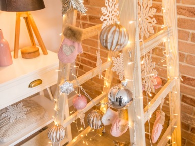 Stojąca w salonie drabina zapewnia dużo świątecznego klimatu. Wiszące dekoracje z bombek i gwiazdek połączone są z drobną girlandą...