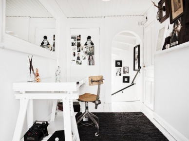 Białe lustro w prostokątnych ramach,białe biurko skandynawskie na kozłach,białe wąskie półeczki ścienne na dekoracje,czarny dywan na białej podłodze (26349)