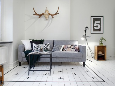 Skandynawski biały salon z szarą sofą i podłogą z pomalowanych desek (21201)