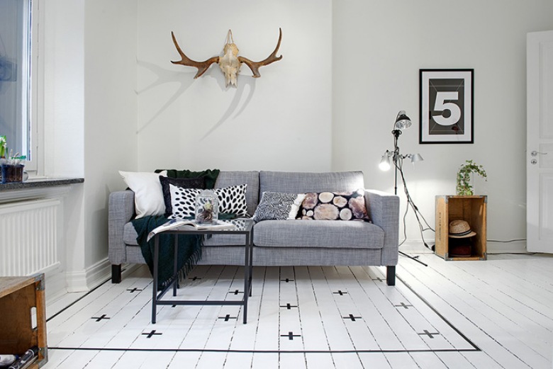 Skandynawski biały salon z szarą sofą i podłogą z pomalowanych desek (21201)