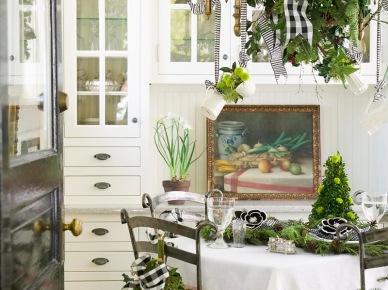 Biała kuchnia tradycyjna z okragłym stołem i kutymi metalowymi krzesłami w światecznej zielonej dekoracji (27403)