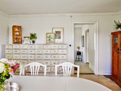 Biała komoda aptekarska z szufladkami,biały stół i białe  drewniane krzesła w jadalni (26005)