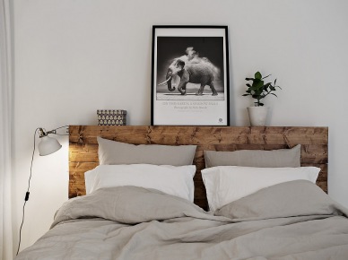 W sypialni kolorystykę szarości ocieplono elementami drewna. Na uwagę zasługuje oryginalne, ale całkiem proste w formie wezgłowie łóżka, które znacząco dekoruje pokój...