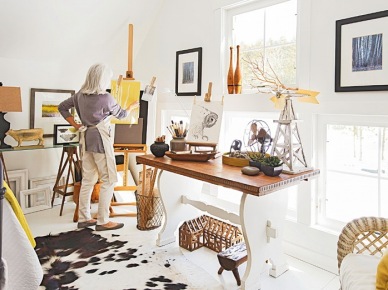 Domowa pracownia w wiejskim stylu z rustykalnym stolem na profilowanej białej podstawie,wikinowe i drewniane pojemniki,dywan biało-czarny z bydlęcej skóry,dekoracyjne gałązki i biały lampion na stole (26164)