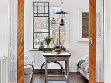 Miodowe drewniane drzwi przesuwne w jadalni ze stołem vintage i rustykalną lampą z metalu i szkła (27870)