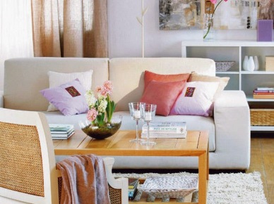 Lniane beżowe zasłony,biała kanapa,łososiowe poduszki i liliowe dodatki w białym salonie (28316)