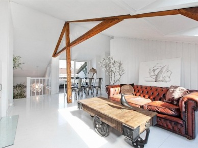 Industrialny stolik z okuciami z drewnianej palety na kólkach i skórzana sofa Chesterfield na poddaszu (24576)