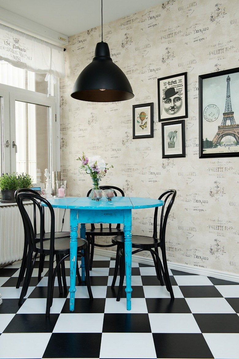 Tapeta ścienna z napisami w stylu vintage,czarna lampa pendant,czarne krzesła z gietego drewna,niebieski okrągły stół i biało-czarna terakota ułożona w szachownicę w kuchni (25860)