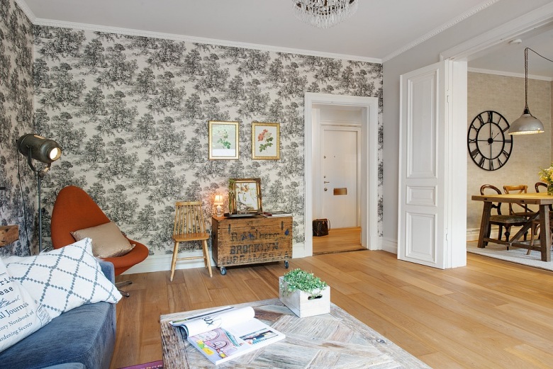 Czarno-biała stylowa tapeta na ścianie w salonie,drewniana skrzynia vintage,pomarańczowy nowoczesny fotek i industrialna lampa reflektor na podłodze (25851)