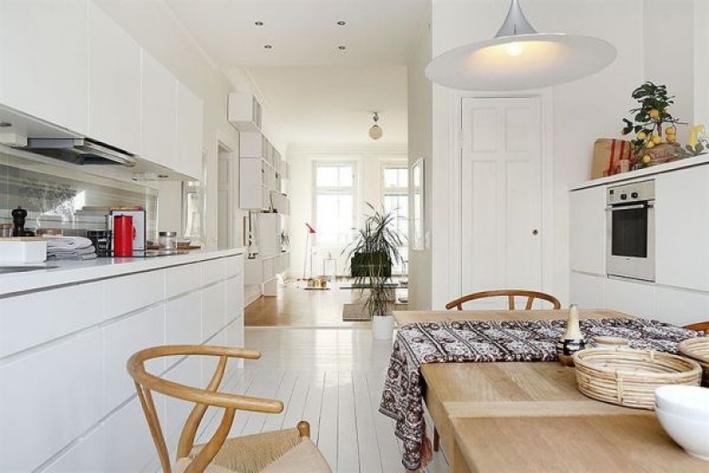 Otwarta przestrzeń białej kuchni z jadalnią i salonem (20955)