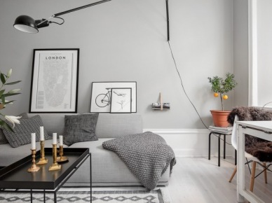 Skandynawskie grafiki,czarny stolik kawowy z tacą blatem,biało-czarny dywan skandynawski i biała podłoga w szarym salonie (26776)
