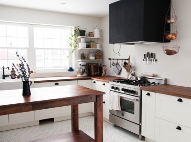 Czarny duży okap w białej kuchni z drewnianym stołem (53098)