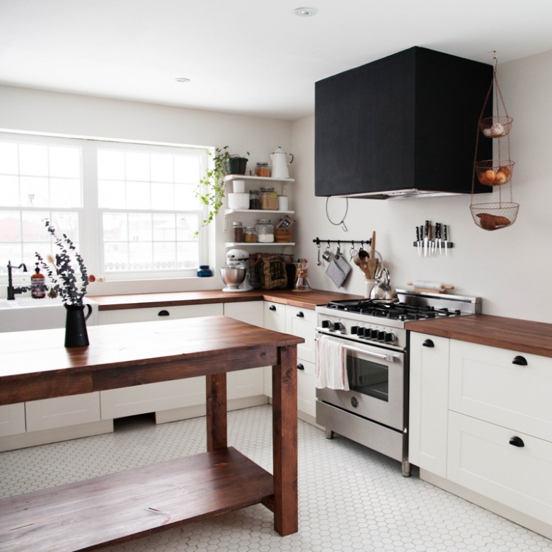 Czarny duży okap w białej kuchni z drewnianym stołem (53098)