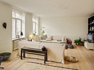 Nowoczesne obrazy,naturalne drewno,tkane dywany i proste witryny w skandynawskim salonie (25402)
