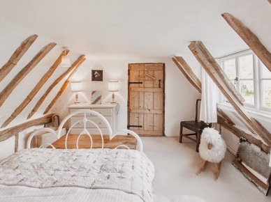 Drewniane wiejskie wrota w aranżacji sypialni z białym kutym łóżkiem na poddaszu (24933)