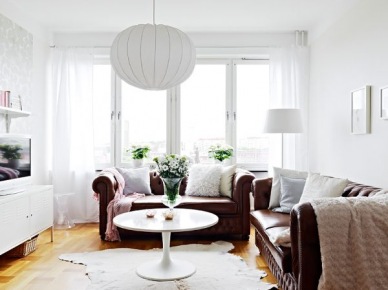 Stylowe skórzane sofy w białym skandynawskim salonie z nowoczesnymi meblami (20441)