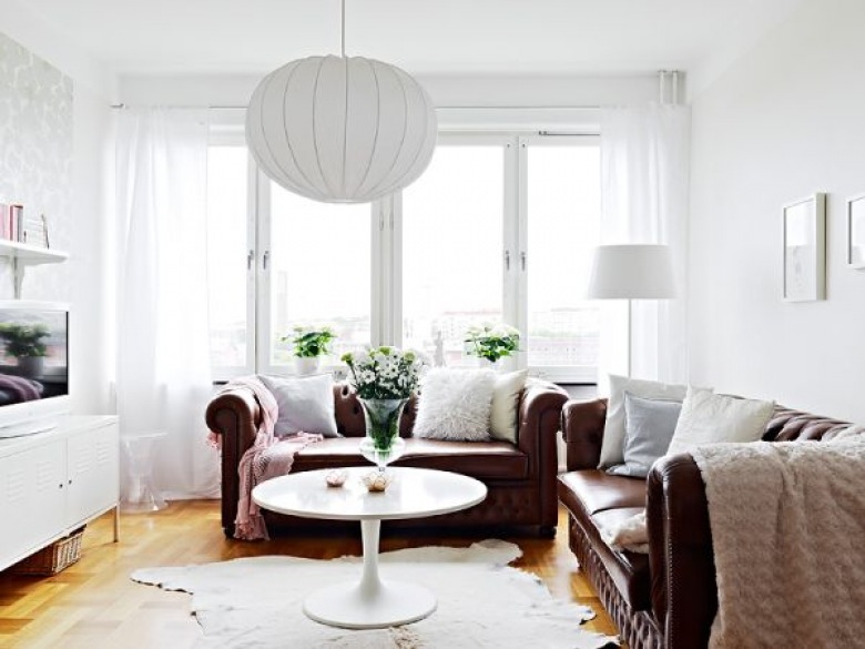 wyjątkowe małe mieszkanie w mieszanym stylu w Skandynawii - uroczy mix skandynawskiego stylu i klasyki. Stylowe biurko, stylowe angielskie, pikowane kanapy ze skóry prezentują się w tym małym 38 m2 mieszkaniu dostojnie i wcale nie przytłaczają małej powierzchni mieszkania. Wytrawna aranżacja w eklektycznym stylu wygląda doskonale w białym mieszkaniu uzupełnionym subtelna tapeta z magnoliami, posadzka czarno-biała ułożona w karo i dodatkowo wtrąconymi współczesnymi krzesłami - jedno neonowe różowe a drugie transparentne. Przykład świetnej mieszanki stylowej...