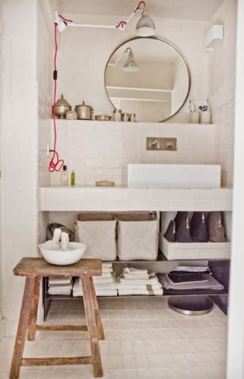 Marokańskie srebrne pojemniki,okragłe lustro,skandynawski kinkiet z wysięgnikiem i drewniany taboret w białej łazience (24955)