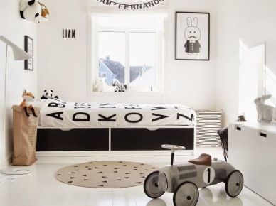 Girlanda z literek na oknie w pokoju dziecięcym,biała pościel z wzorem czarnych literek,biało-czarne łóżko dziecięce w białej aranżacji pokoju (28505)