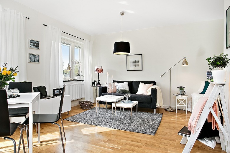 Otwarty salon z jadalnią w jednopokojowym mieszkaniu w biało-szaro-czarnych kolorach (23545)