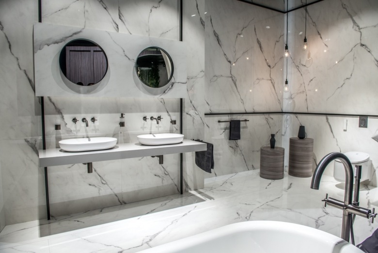 Aranżacja łazienki przewiduje dwa stanowiska z dwoma umywalkami i lustrami. Biało-szary kamień dodaje jej elegancji....