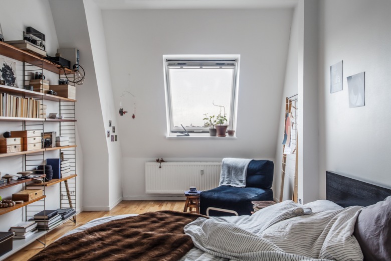 Skandynawska sypialnia z ażurowymi pólkami i granatowym fotelem (23511)