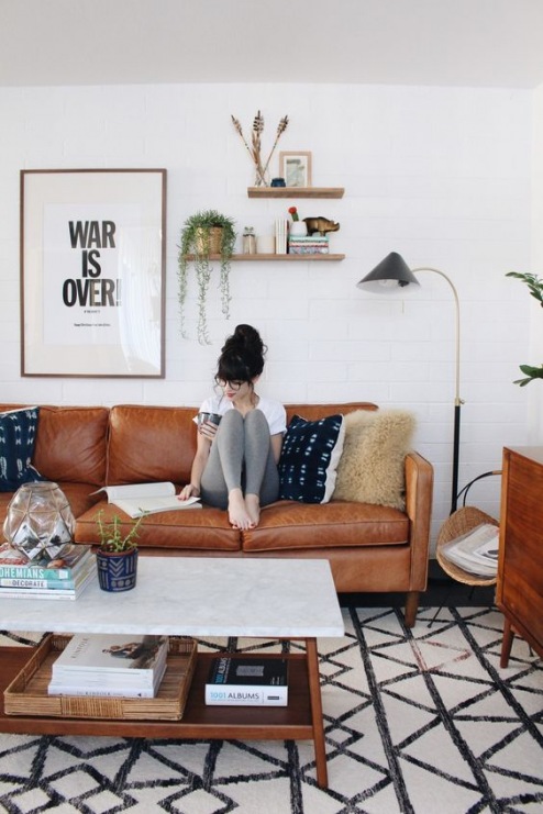 Skórzana sofa w salonie dodaje wyjątkowego klimatu aranżacji. Wzorzysty dywan, typografia na ścianie czy drobne rośliny...