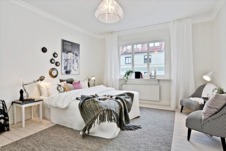 Foteliki z tapicerką w pepitkę,szary tkany dywan,nowoczesne grafiki i kolorowe poduszki na białym łóżku w sypialni skandynawskiej (27704)